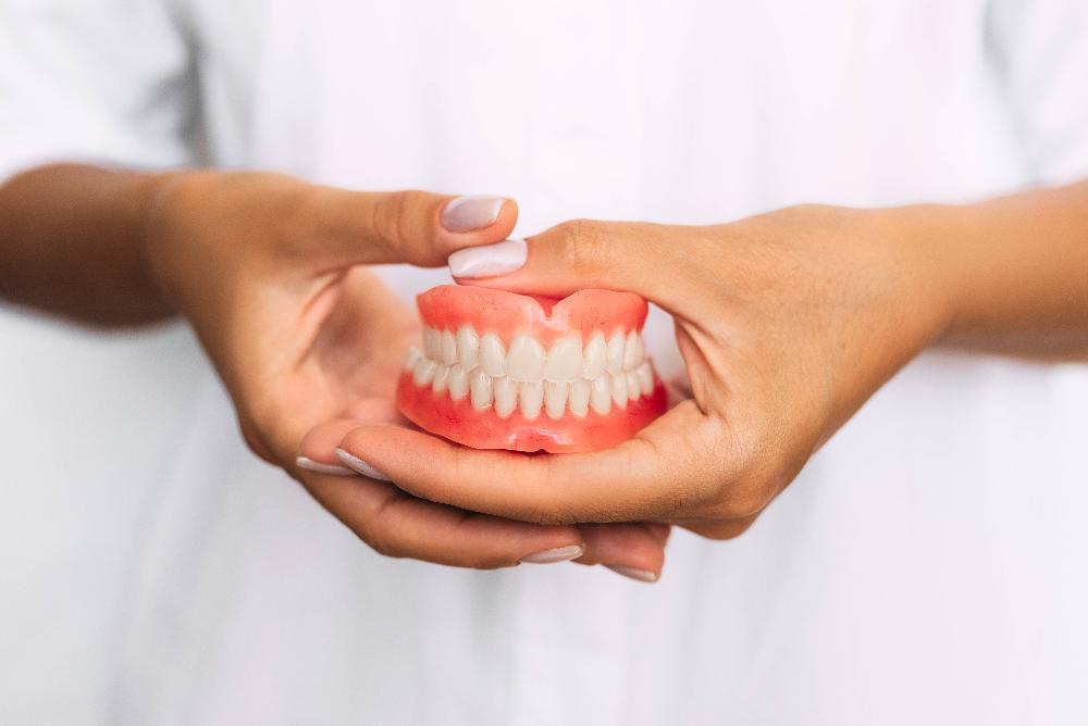 person holding denture mold | dentures akron