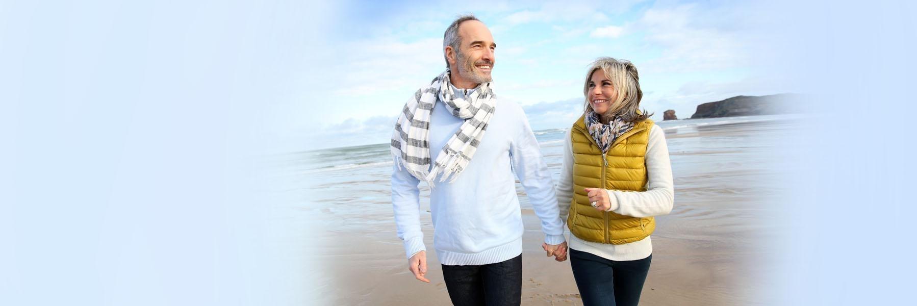older couple walking on beach | dentures near me